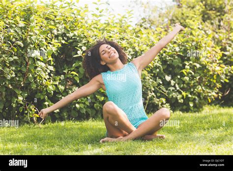 Gorgeous Content Brunette Sitting On Grass Stretching Arms Stock Photo Alamy