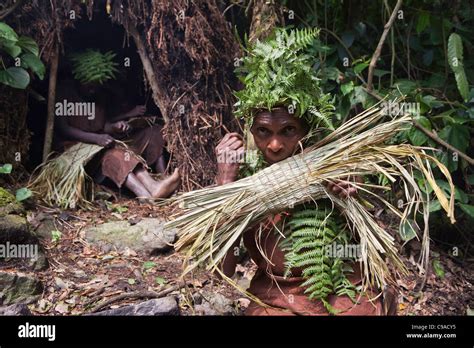 Batwa Woman In Traditional Dress Uses Reeds To Make A Basket Batwa