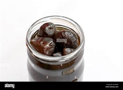 Picture Of An Open Jar Of Preserved Figs On White Background Stock