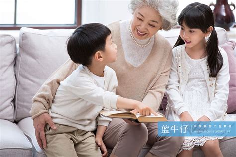 开心的奶奶和孙子孙女在沙发上看书 蓝牛仔影像 中国原创广告影像素材