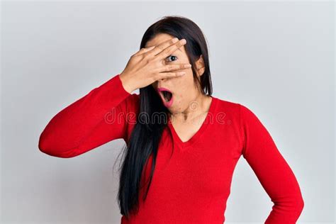 Young Latin Woman Wearing Casual Clothes Peeking In Shock Covering Face