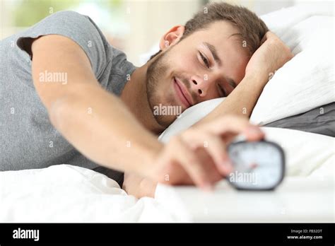 Happy Wake Up Of A Happy Man Lying On The Bed And Stopping Alarm Clock