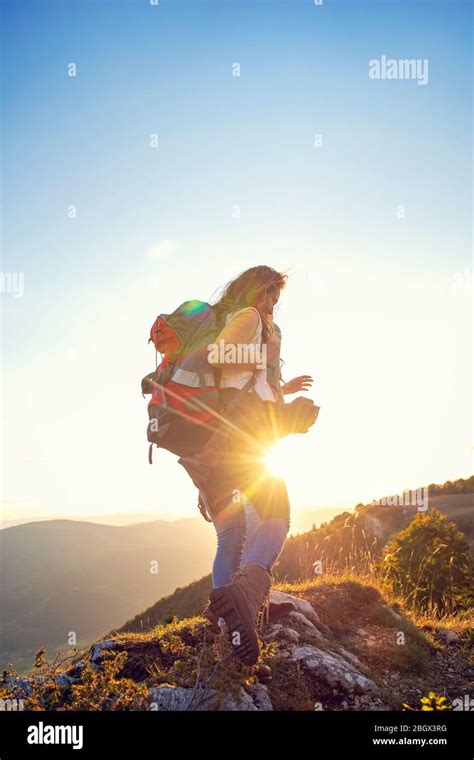 Hikers With Backpacks Relaxing On Top Of A Mountain And Enjoying The