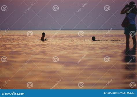 Schattenbild Der Familie Im Meer Gegen Den Sonnenuntergang