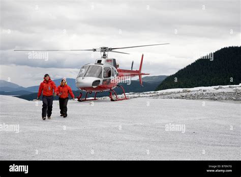 Helicopter tour guides walk from helicopter on top of Mendenhall ...