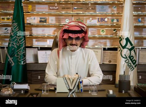 A portrait of His Royal Highness Prince Al Waleed Bin Talal Al-Saud at his desk in front of a ...