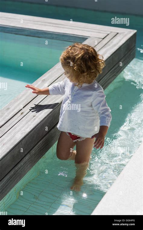 Baby girl playing in water Stock Photo - Alamy