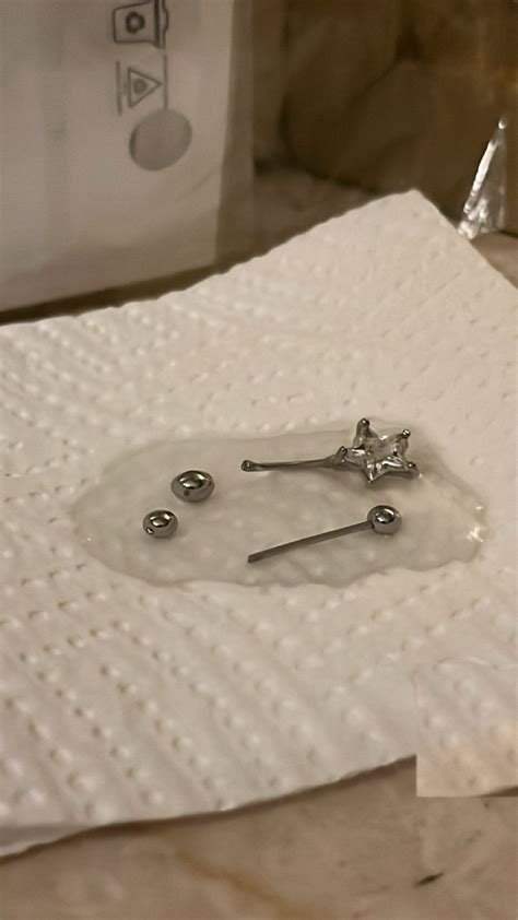 A Pair Of Screws Sitting On Top Of A Piece Of White Paper With Holes In It