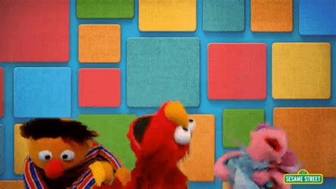 The Sesame Street Characters Are Standing In Front Of Colorful Blocks