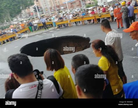 Two Vehicles Are Trapped In A Sink Hole Caused By The Collapse Of The