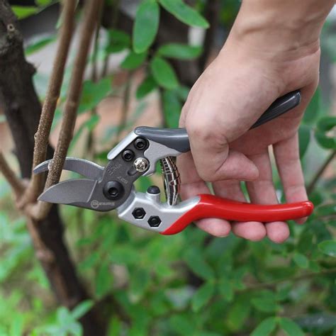 A Person Holding A Pair Of Pliers In Their Hand While They Are Cutting