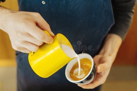 Close Up Of Barista Pouring Steamed Milk Into Coffee Cup Making Latte