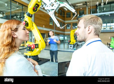 Engineers inspect industrial robot Stock Photo - Alamy