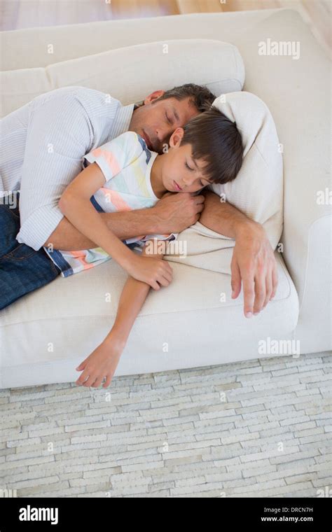 Father And Son Napping On Sofa In Living Room Stock Photo Alamy