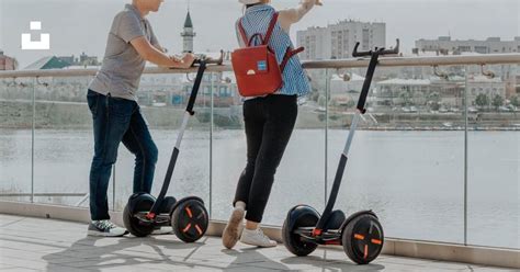 Two People Riding Segways Near the Water