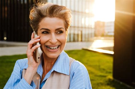 Mature Grey Woman Laughing While Talking On Mobile Phone Stock Image