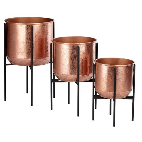 Three Metal Planters Sitting Next To Each Other On Top Of Black Stand