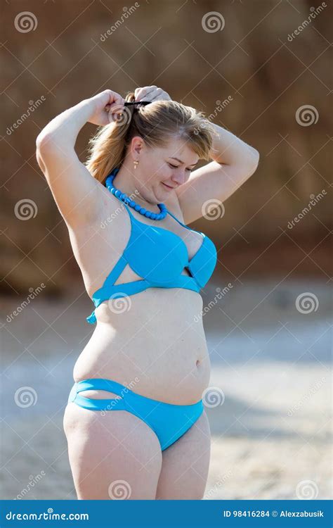 Overweight Woman In Blue Bikini Adjusting Her Hairstyle On Seashore