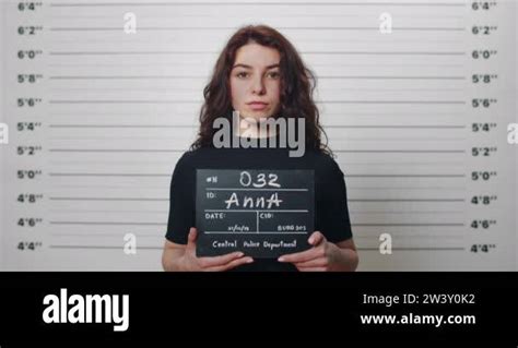 Mugshot Of Millennial Arrested Woman With Curly Hair Being Photographed