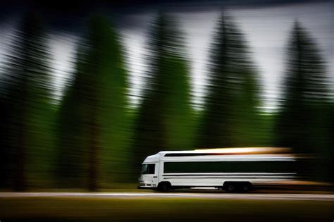 Premium Ai Image Truck Speeding Past Forest With Blurry Trees In The