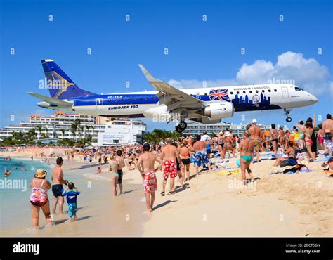 Embraer 190 (E190) extreme low approach to St. Maarten Airport over Maho Beach. ERJ-190 aircraft ...