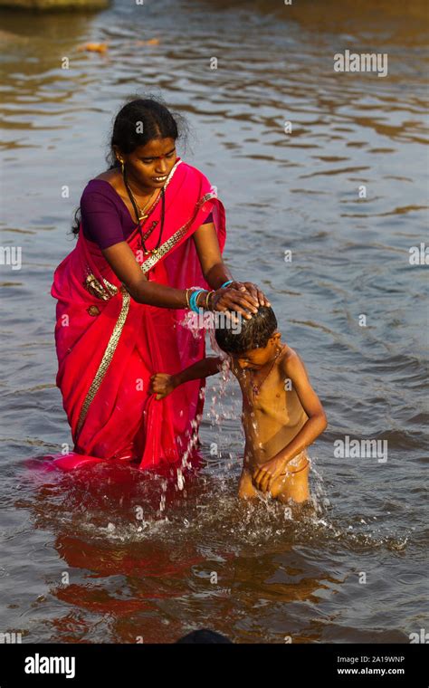 Indian Mother Bathing His Son At Tungabhadra River Hampi Karnataka