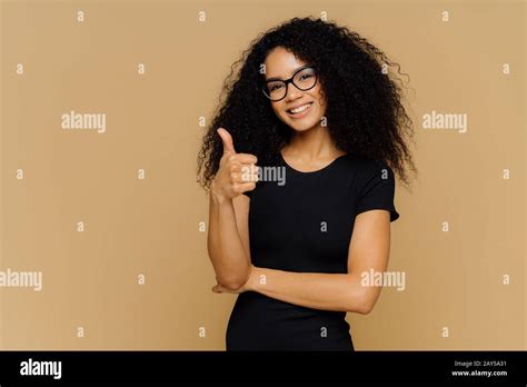 I Totally Agree Good Looking Satisfied Afro American Woman Keeps Thumb