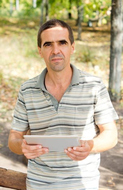 Premium Photo Attractive Middleaged Man Holding A Tablet In His Hands