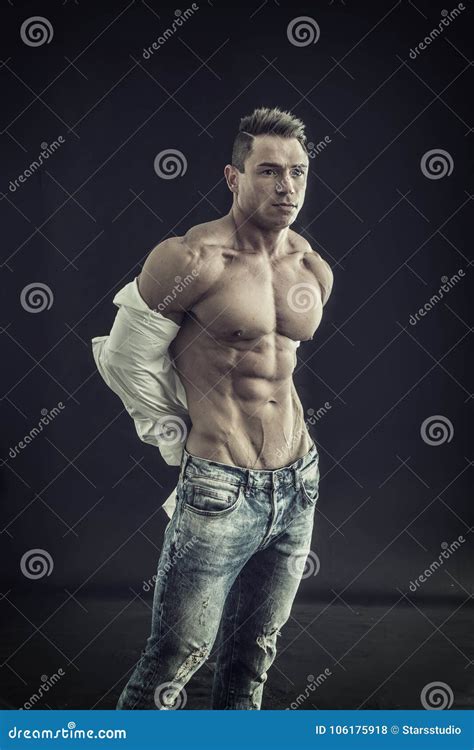 Male Bodybuilder Opening His Shirt Revealing Muscular Torso Stock Photo