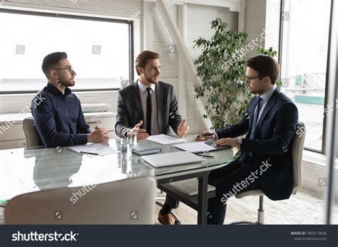 Confident Diverse Business Partners Discussing Contract Stock Photo