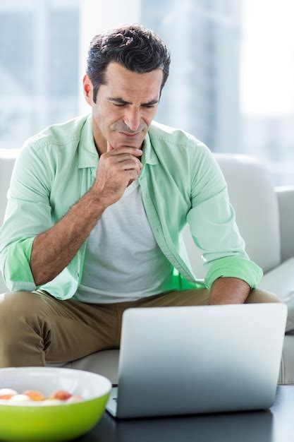 Homem Concentrado Usando O Laptop Em Casa Foto Premium