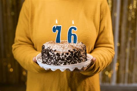 Woman Holding A Festive Cake With Number 76 Candles While Celebrating Birthday Party Birthday