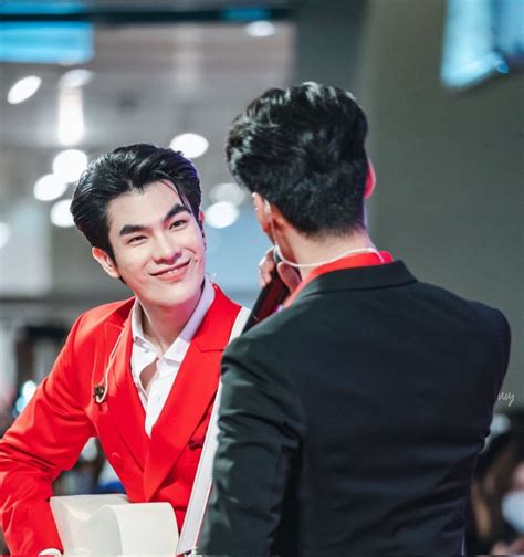 A Man In A Red Suit Talking To Another Man