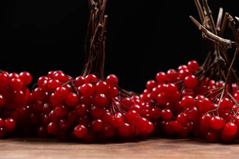 Premium Photo A Bunch Of Ripe Viburnum Berries On A Black Background