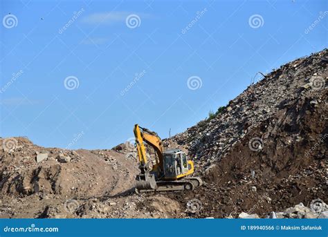 Yellow Excavator At Landfill For Disposal Of Construction Waste