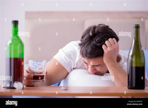 Man Alcoholic Drinking In Bed Going Through Break Up Depression Stock