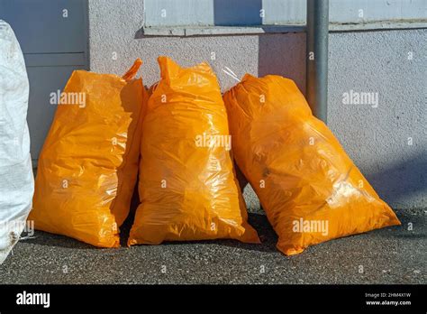 Three Orange Garbage Bags At Street Recycling Collection Stock Photo