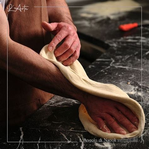 A Man Is Kneading Dough On Top Of A Black Counter With His Hands