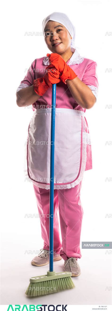 Portrait Of A Cleaning Lady Wearing Gloves And Apron Holding A Hand Broom Chores And Chores