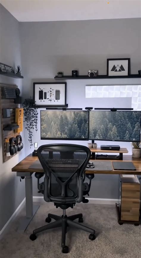 A Home Office With Two Computer Screens On The Wall