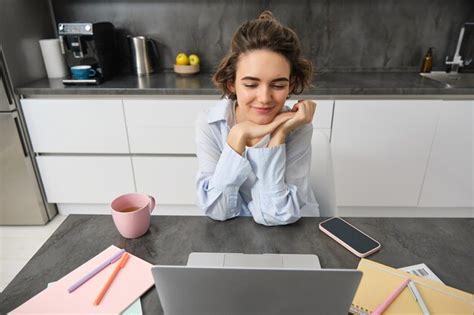 Hermosa mujer morena mirando una computadora portátil sentada en casa y