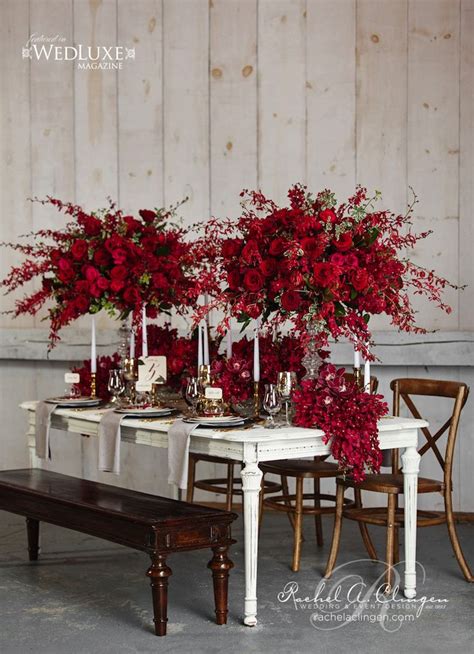 The Table Is Set With Red Flowers And Candles