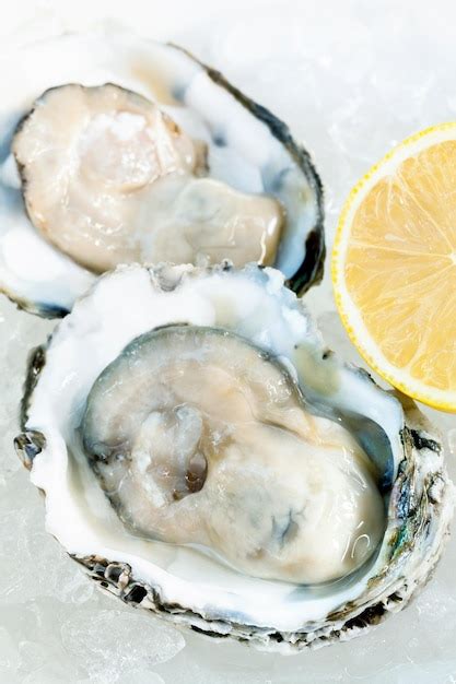 Premium Photo Close Up Of Oyster And Lemon Slice On Table