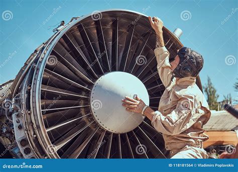 Mechanic In Uniform And Flying Helmet Repairing The Dismantled Airplane ...