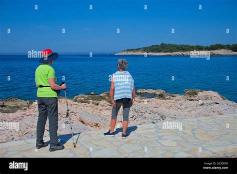 Two Senior Women Walking Along The Sea Shore Stock Photo Alamy