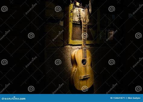 An Wooden Acoustic Guitar Is Against A Grunge Textured Wall The Room