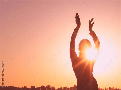 Dark Glowing Silhouette Of Slim Woman With Hands Up In The Air