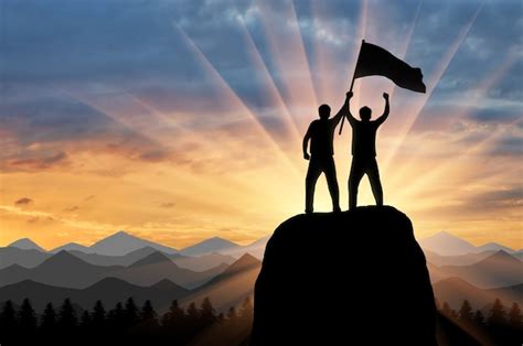 Silhueta De Dois Alpinistas No Topo De Uma Montanha Uma Bandeira Na