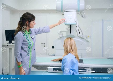 Radiologic Technologist Preparing Adult Female For Upper Extremity