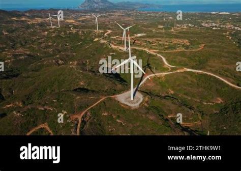 Aerial Establishing Shot Of Wind Turbines Rotating And Generating Green